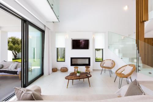 a living room with a fireplace and a tv at Elegante Villa Mit Beheiztem Pool Und Fantastischer Aussicht in Skouloúfia