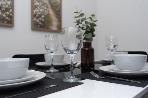 a table with plates and wine glasses on it at Wellington - Telford house - With parking in Wellington