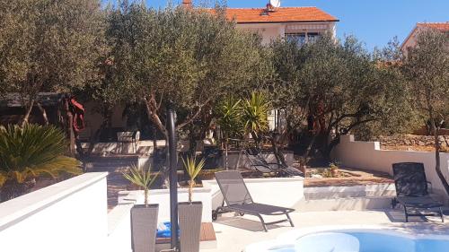 een patio met stoelen en bomen en een zwembad bij Komplex Oliva Mit Pool Und Großem Garten in Stari Grad