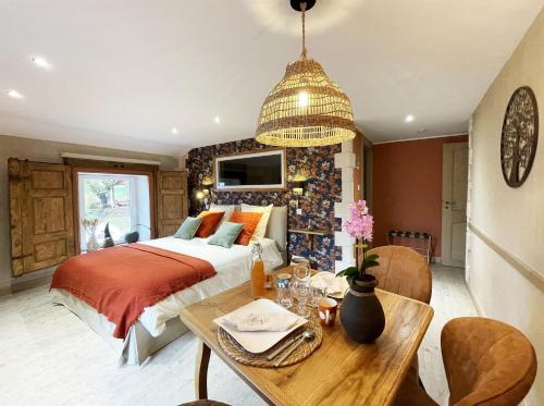 een slaapkamer met een bed en een tafel en een eetkamer bij Chtite Vosgienne Gîte 4 étoiles cosy in Vecoux