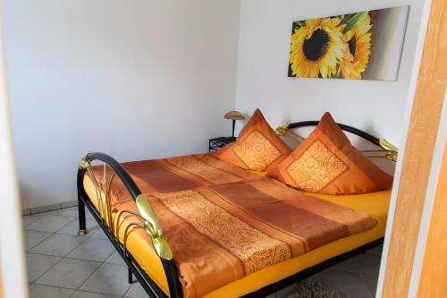 un lit avec des oreillers orange dessus dans une chambre dans l'établissement Ferienhaus Stahlberg, à Babelsberg