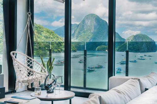 a room with a view of the water and mountains at H Hotel El Nido - Vegan Friendly Hotel Managed by H Hospitality Group in El Nido
