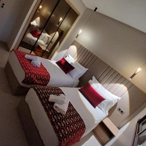 a bedroom with two beds with red and white pillows at Suites El Ghailani in Dakhla