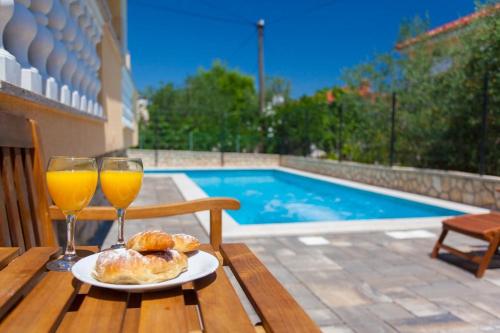 einen Tisch mit zwei Gläsern Orangensaft und einem Teller Essen in der Unterkunft Studio für 2 Personen  2 Kinder ca 35 qm in Šilo, Kvarner Bucht Krk in Šilo