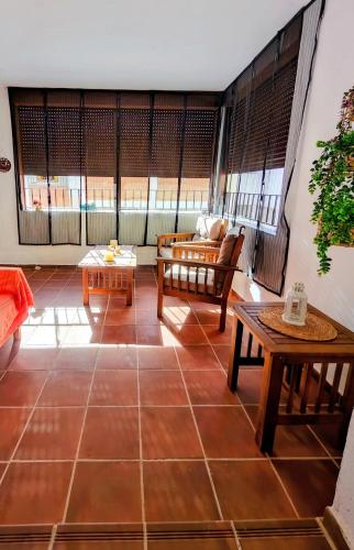 a living room with tables and chairs in a room at Casona El Chaparral in Fondón