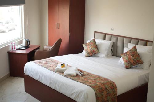 a hotel room with a bed with towels on it at The Millennium Kashi Hotel in Varanasi
