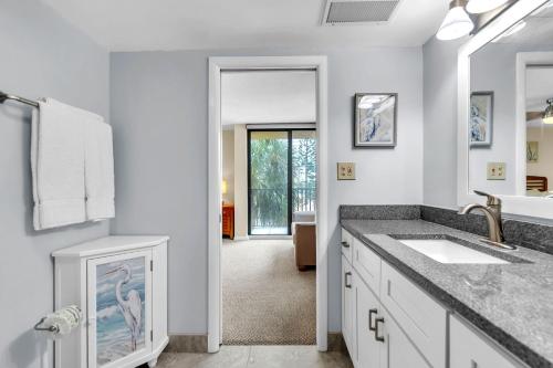 a white bathroom with a sink and a mirror at Trillium 2A - Premier in St. Pete Beach
