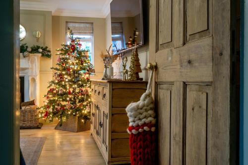 a kitchen with a christmas tree and a door at Cherry Trees Farmhouse in Nether Broughton