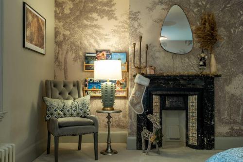 a living room with a chair and a mirror at Cherry Trees Farmhouse in Nether Broughton