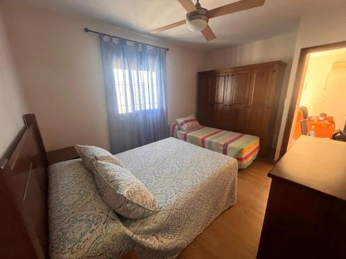 a bedroom with a bed and a dresser and a window at Chalet Playa Paraiso in Cádiz