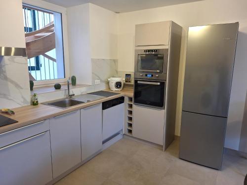 ベルジェール・レ・ヴェルテュにあるGite en Champagneのステンレス製の冷蔵庫とシンクを備えたキッチン