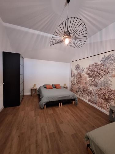 a bedroom with a bed and a chandelier at Gite en Champagne in Vertus