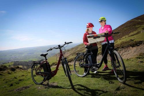 a man and woman holding a box on their bikes at Glan Llyn Farm House in Mold