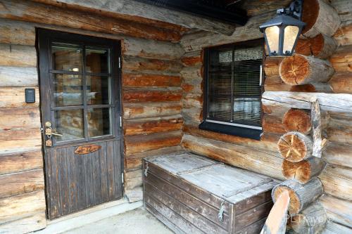 a wooden cabin with a door and a window at Holiday Home Hopukka F12 in Luosto