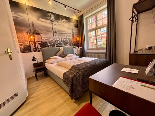 a small bedroom with a bed and a desk at Bio Boutique Hotel Barbara in Freiburg im Breisgau
