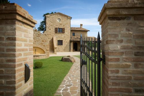 an entrance to a stone house with a black gate at VILLA ERMELINDA - Ville Carborello in Castelraimondo