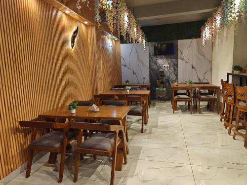 a restaurant with wooden tables and chairs and lights at Tathastu Stay in Dehradun