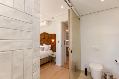Un baño con inodoro y una cama en una habitación. en Aan de Meul Luxury Apartments, en Stellenbosch