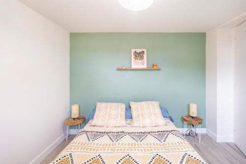 a bedroom with a bed with a blue wall at Séjour Entre Océan et Centre-Ville in Hossegor