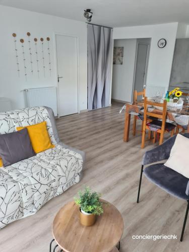 ein Wohnzimmer mit Sofa und Tisch in der Unterkunft Chez Tina jolie maison à 12 min du Puy du Fou in Les Herbiers