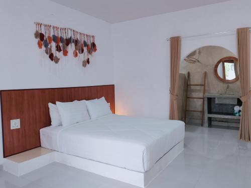 a bedroom with a large white bed and a fireplace at My Boo Private House in Sampalan