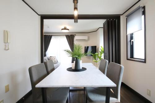 a dining room with a white table and chairs at Corp F Haneda in Tokyo