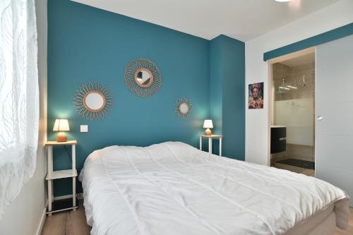 a blue bedroom with a bed and two mirrors at Ker Ostrea - Moins dun km de la plage in Cancale