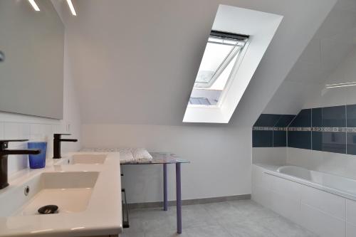 a bathroom with a sink and a tub and a window at Ker Ostrea - Moins dun km de la plage in Cancale
