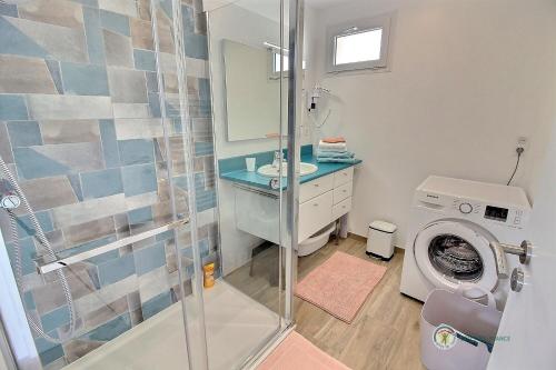 een badkamer met douche en wasmachine bij Le p'tit ancrage in Erquy