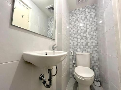 ein weißes Badezimmer mit Waschbecken und Toilette in der Unterkunft Apartment Tokyo Riverside By Seagull Luxury Apartment in Gedong