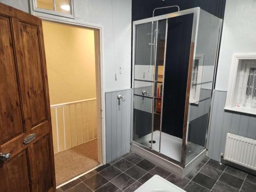 a bathroom with a shower and a glass shower stall at Hartwood Cottage - 33 Longwestgate in Scarborough