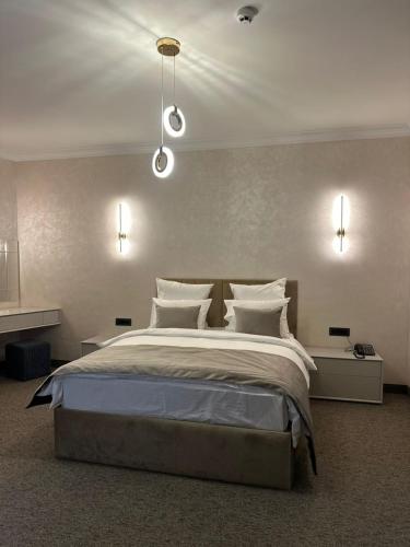 a bedroom with a large bed with white pillows at Nord Gate Avenue Hotel in Aghk'ilisa