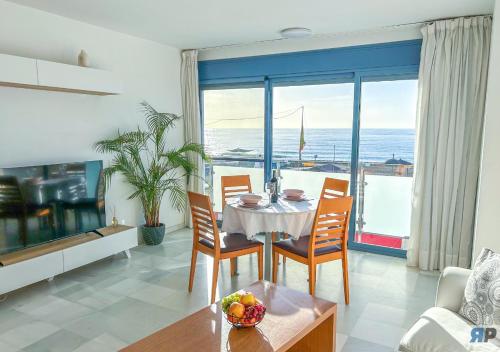 ein Esszimmer mit Tisch und Blick auf das Meer in der Unterkunft Apartamentos Varadero Sea View in La Cala del Moral