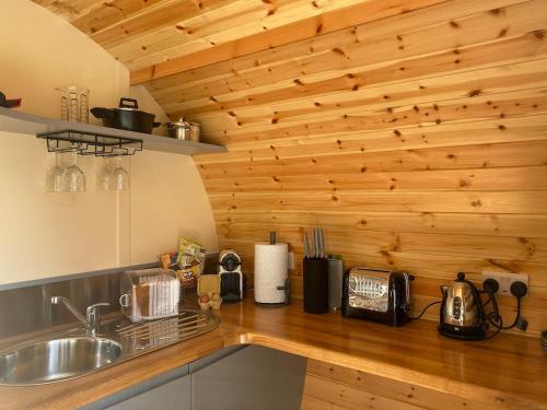 - une cuisine avec un évier et un mur en bois dans l'établissement Willowbrook Luxury Log Cabin with private hot tub, à Kings Norton