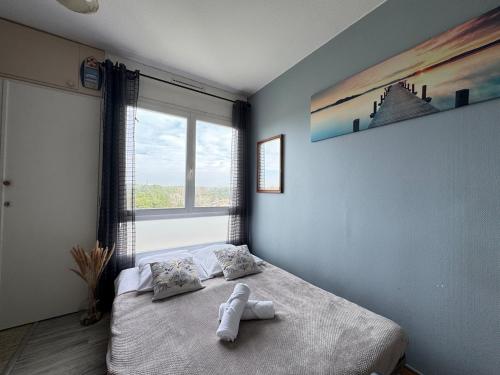 a bedroom with a bed with a towel on it at Le Pignon - TV, 1min de la Mer, Central in Saint-Jean-de-Monts