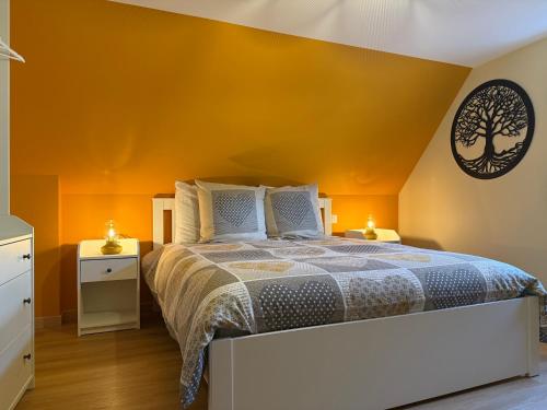 a bedroom with orange walls and a white bed at S'Nekel Hisel - Gîte à Offwiller in Offwiller