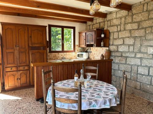 a kitchen with a table with two chairs and a kitchen with a tableablish at Maison de Charme Vue Exceptionnelle Mer & Montagne in Campomoro