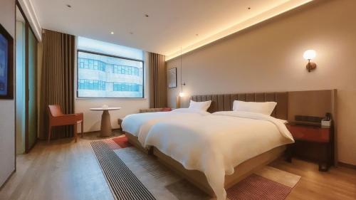 Un dormitorio con una cama grande y una ventana grande en W9-Hotel ShangHai PuDong Airport, en Shanghái
