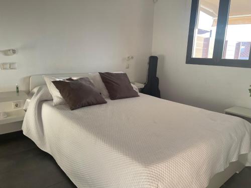 a white bed with two pillows on top of it at Bungalow Maspalomas, Jacuzzi in Maspalomas