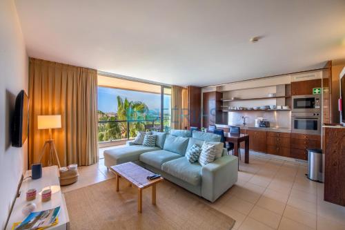 a living room with a couch and a kitchen at Apartments Herdade dos Salgados by PCFerias in Albufeira