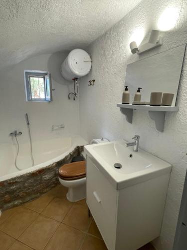 a white bathroom with a toilet and a sink at Rose Home in Areopoli