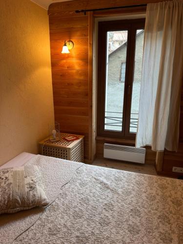 a bedroom with a large bed and a window at 2 pièces Suzie in Saint-Étienne-de-Tinée