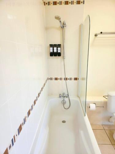 a white bath tub in a bathroom with a shower at Spacious N3, quiet,great location in Divonne-les-Bains