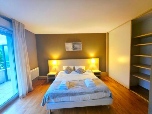 a bedroom with a large bed with two lamps at Spacious N3, quiet,great location in Divonne-les-Bains