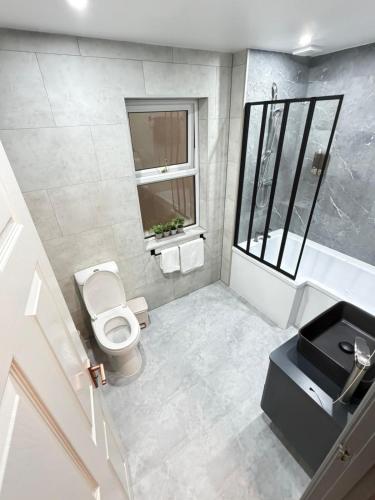 a white bathroom with a toilet and a sink at Seaside Retreat in Harrington
