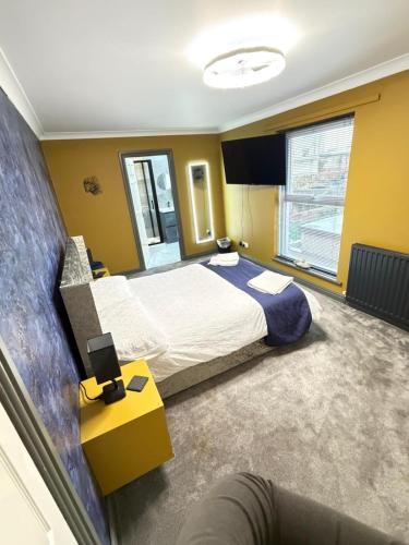 a bedroom with a large bed and a yellow wall at Seaside Retreat in Harrington
