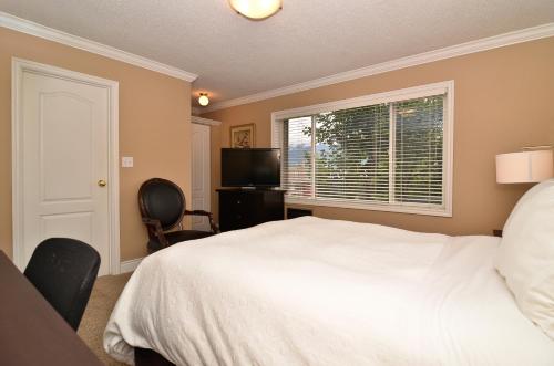 a bedroom with a white bed and a window at Regent Hotel Revelstoke in Revelstoke