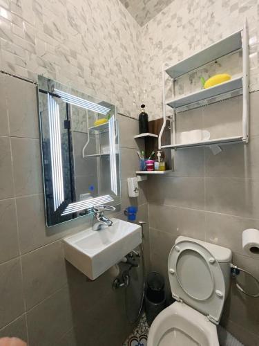 a bathroom with a toilet and a sink and a window at Apprt cosy près plage des Nations in Salé