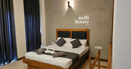 een slaapkamer met een groot bed met twee kussens bij nelli house in Galle