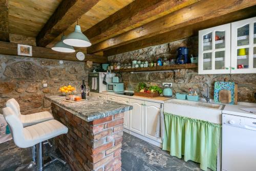 a kitchen with white appliances and a brick wall at Paun in Bribir